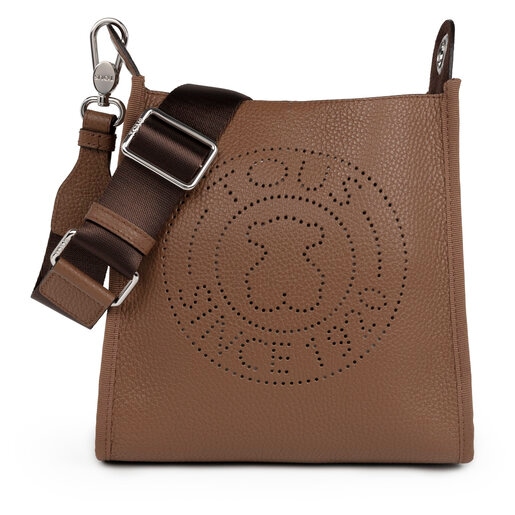 TOUS small crossbody bag from the Leissa collection in brown-colored  die-cut leather. Zipper closure. Adjustable crossbody strap. Flat interior  pocket. The crossbody bag includes a red decorative pendant. Handbag  measurement: 15.5 x 21 x 7 cm.