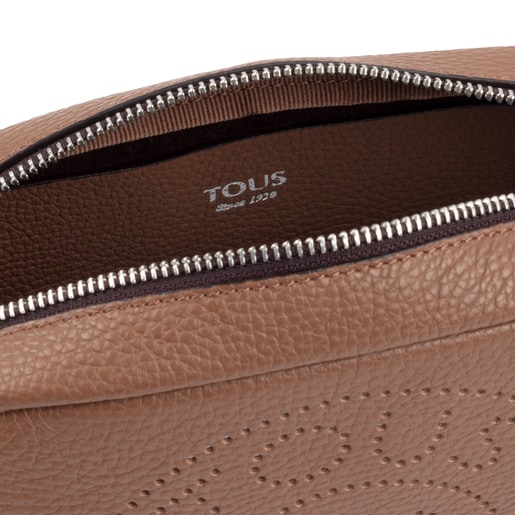 TOUS small crossbody bag from the Leissa collection in brown-colored  die-cut leather. Zipper closure. Adjustable crossbody strap. Flat interior  pocket. The crossbody bag includes a red decorative pendant. Handbag  measurement: 15.5 x 21 x 7 cm.