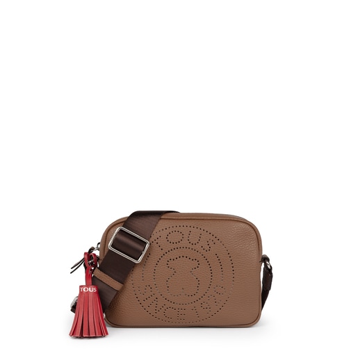 TOUS small crossbody bag from the Leissa collection in brown-colored  die-cut leather. Zipper closure. Adjustable crossbody strap. Flat interior  pocket. The crossbody bag includes a red decorative pendant. Handbag  measurement: 15.5 x 21 x 7 cm. |