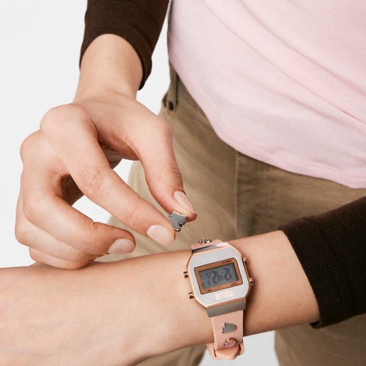 ساعة رقمية بحزام باللون الوردي، وهيكل من الصُلب باللون الوردي، ومرصعة بالأحجار الكريمة من تشكيلة TOUS XPRESURSLF